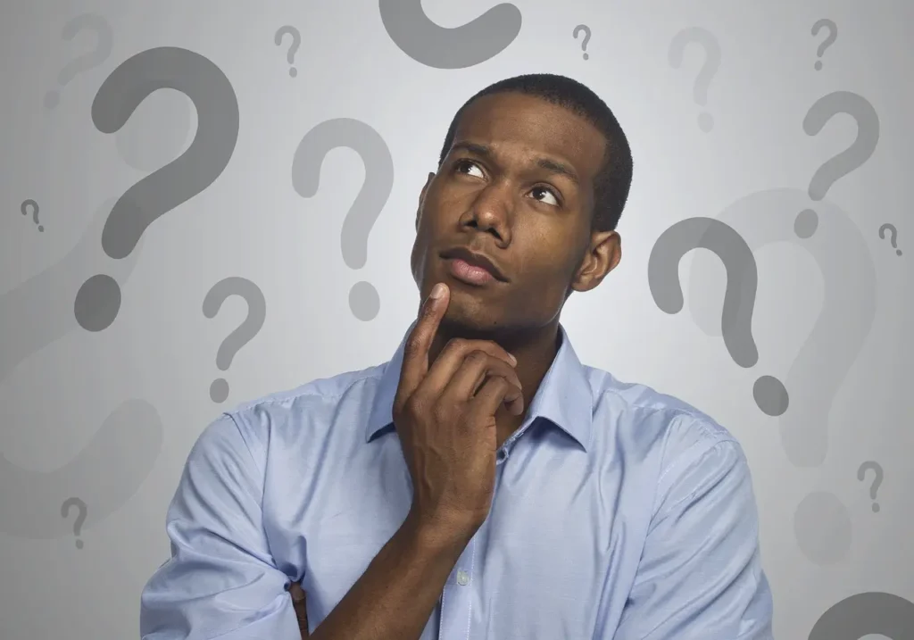 Mann grübelt vor einem Hintergrund mit Fragezeichen