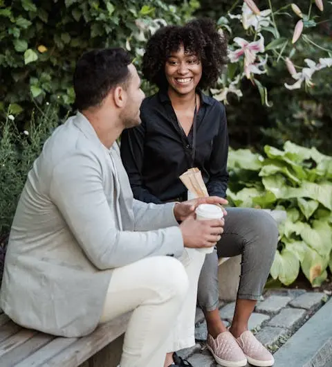 Freunde unterhalten sich auf einer Parkbank sitzend